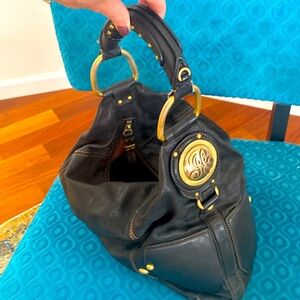 Black leather with gold accents Juicy couture sling bag.